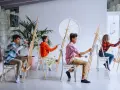 Des enfants concentrés sur leur peinture sur petite toile facile, chacun sur son chevalet, dans un atelier lumineux.