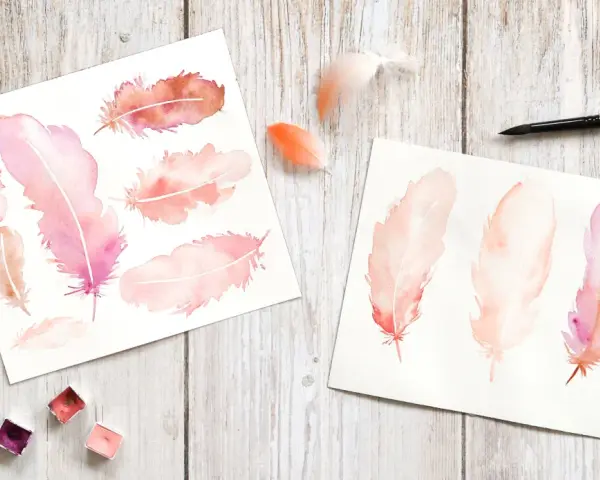 Aquarelles de plumes roses et orangées sur papier, avec des godets de peinture acrylique et un pinceau.