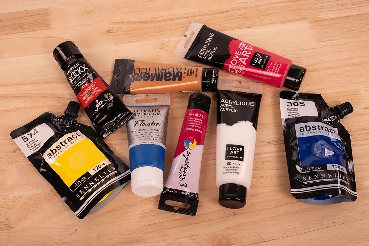 Un assortiment de tubes et pochettes de peinture acrylique aux couleurs vives, parfait pour enrichir votre vocabulaire peinture.